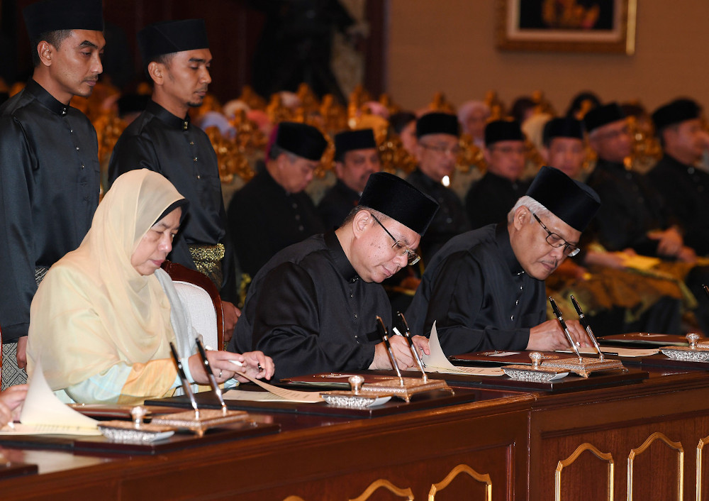 Communications and Multimedia Minister Datuk Saifuddin Abdullah with Housing and Local Government Minister Zuraida Kamaruddin and Home Minister Datuk Seri Hamzah Zainuddin sign their appointment letters at Istana Melawati March 10, 2020. u00e2u20acu201d Bernama pic  