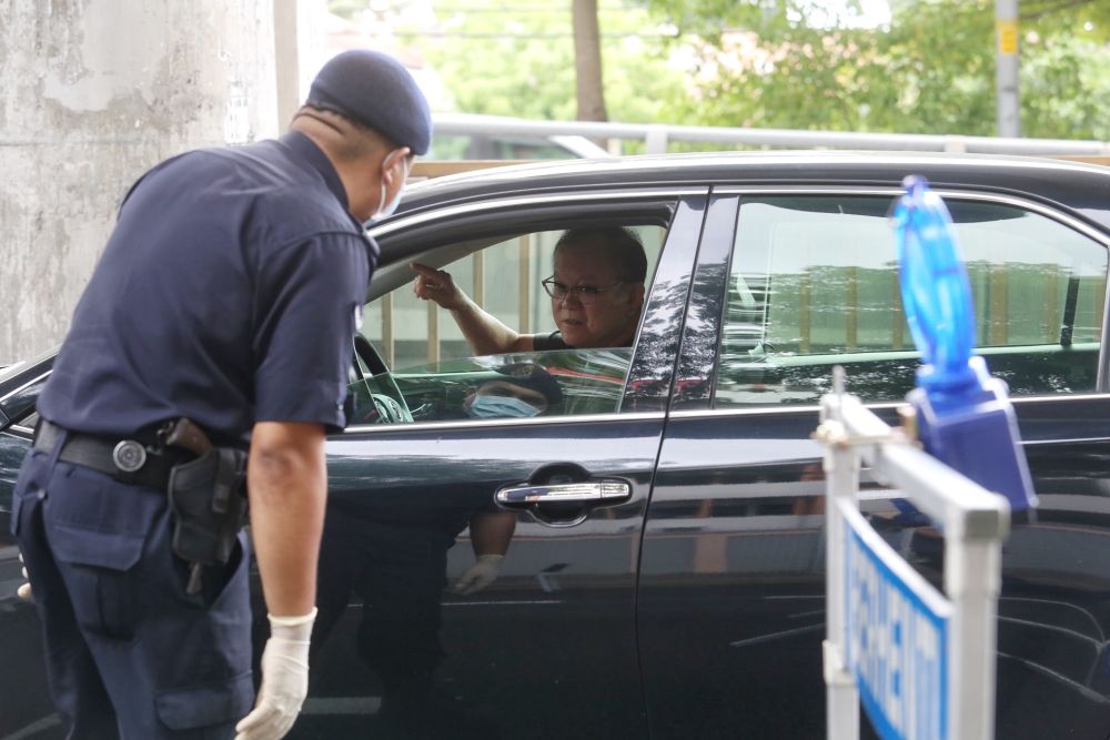 Police personnel inspects a vehicle at a roadblock in Subang Jaya on Day Two of the movement control order March 19, 2020. u00e2u20acu201d Picture by Choo Choy May