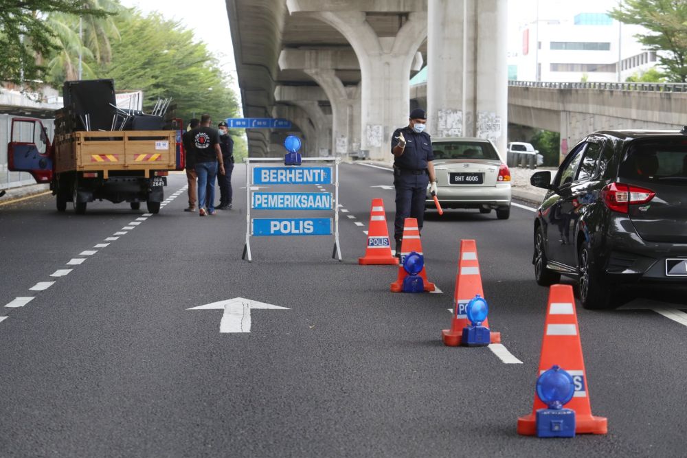 Police personnel inspect vehicles at a roadblock in Subang Jaya on Day Two of the movement control order March 19, 2020. u00e2u20acu201d Picture by Choo Choy May