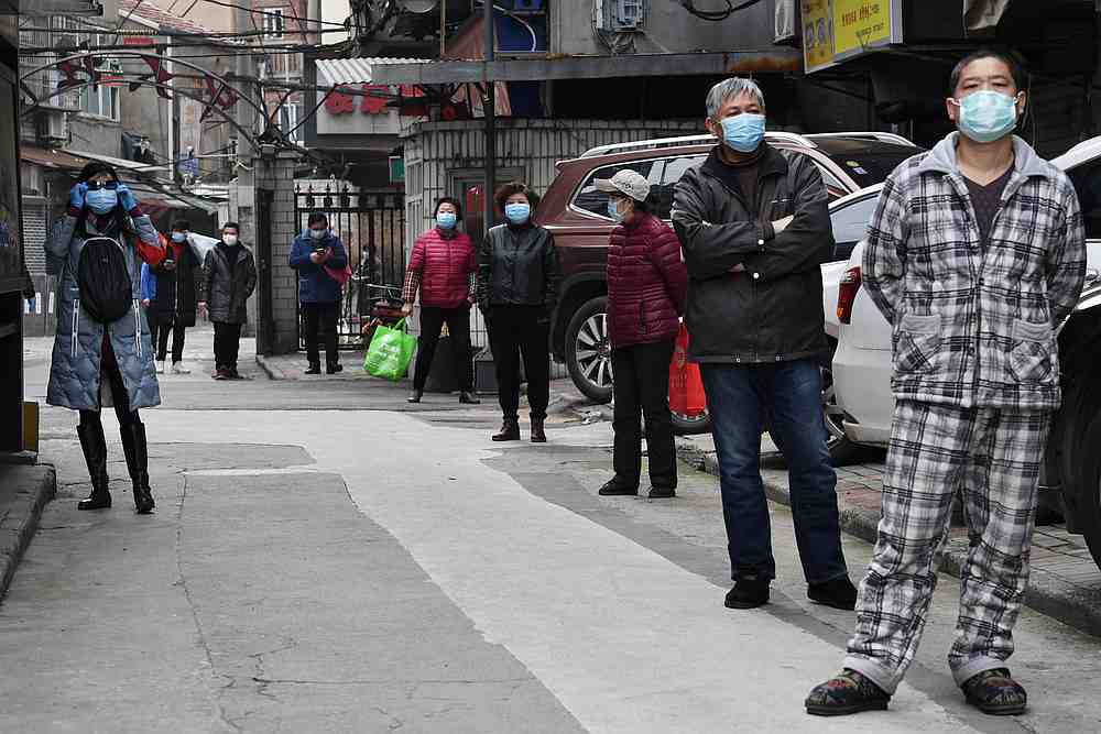 Residents line up to collect vegetables purchased through group orders at a residential area in Wuhan, Hubei province, China March 5, 2020. u00e2u20acu201d Reuters pic 