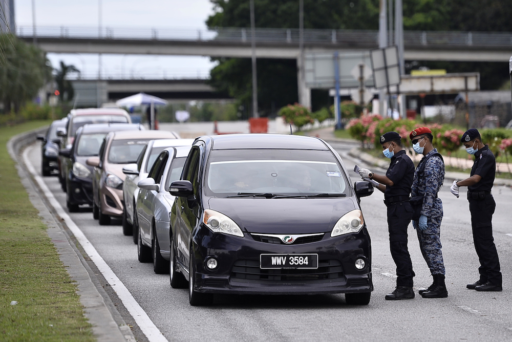 Army and police personnel conducting roadblock checks during the movement control order (MCO) in Shah Alam April 5, 2020. u00e2u20acu201d Picture by Miera Zulyana