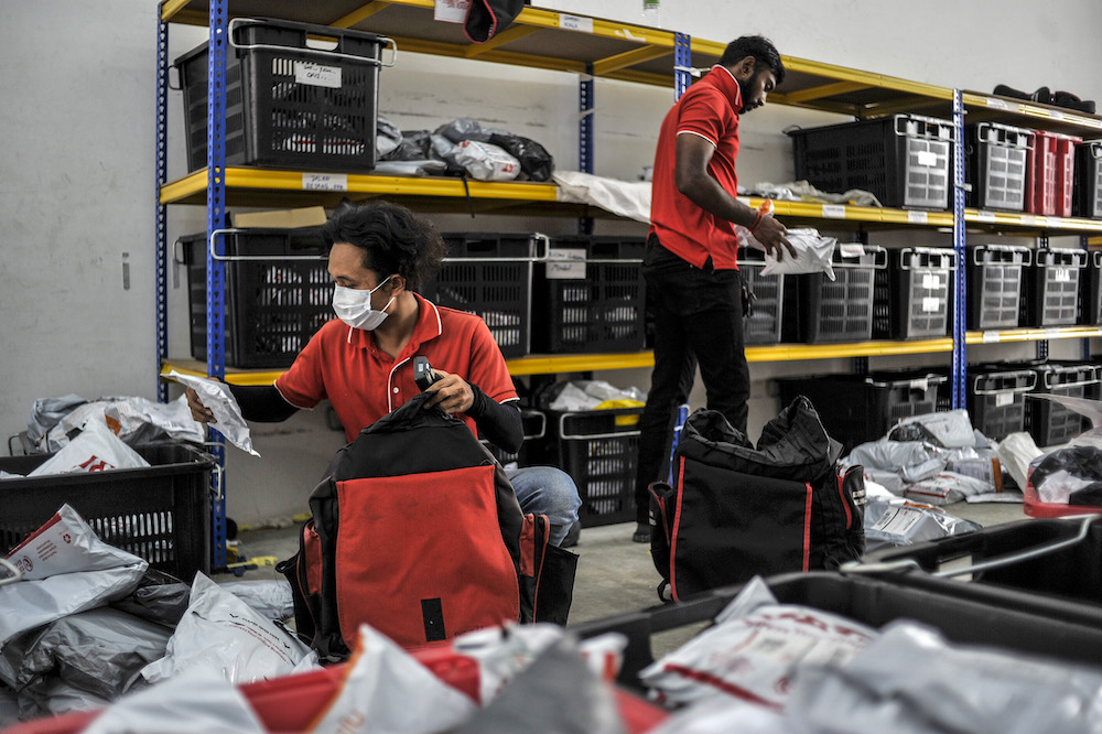 Staff of courier service company J&T Express check parcels that are ready for delivery at their warehouse in Seri Rampai April 7, 2020. u00e2u20acu201d Picture by Shafwan Zaidon