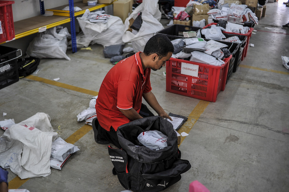 Staff of courier service company J&T Express check parcels that are ready for delivery at their warehouse in Seri Rampai April 7, 2020. u00e2u20acu201d Picture by Shafwan Zaidon