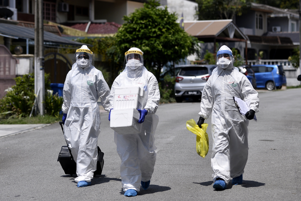 Health workers in protective suits are seen after conducting Covid-19 testing at Lorong Jalan Puyuh, Shah Alam April 12, 2020. u00e2u20acu201d Picture by Miera Zulyana
