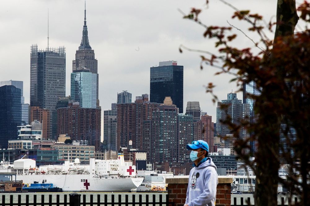 A man wears a face mask while the USNS Comfort and the Empire State Building are seen from Weehawken, New Jersey, during the outbreak of the coronavirus disease in New York March 31, 2020. u00e2u20acu201d Reuters pic