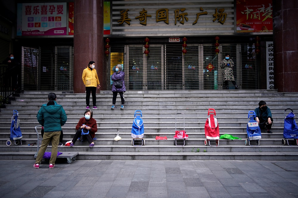 People wearing face masks wait for a supermarket to open in Wuhan, Hubei province April 5, 2020. u00e2u20acu201d Reuters pic