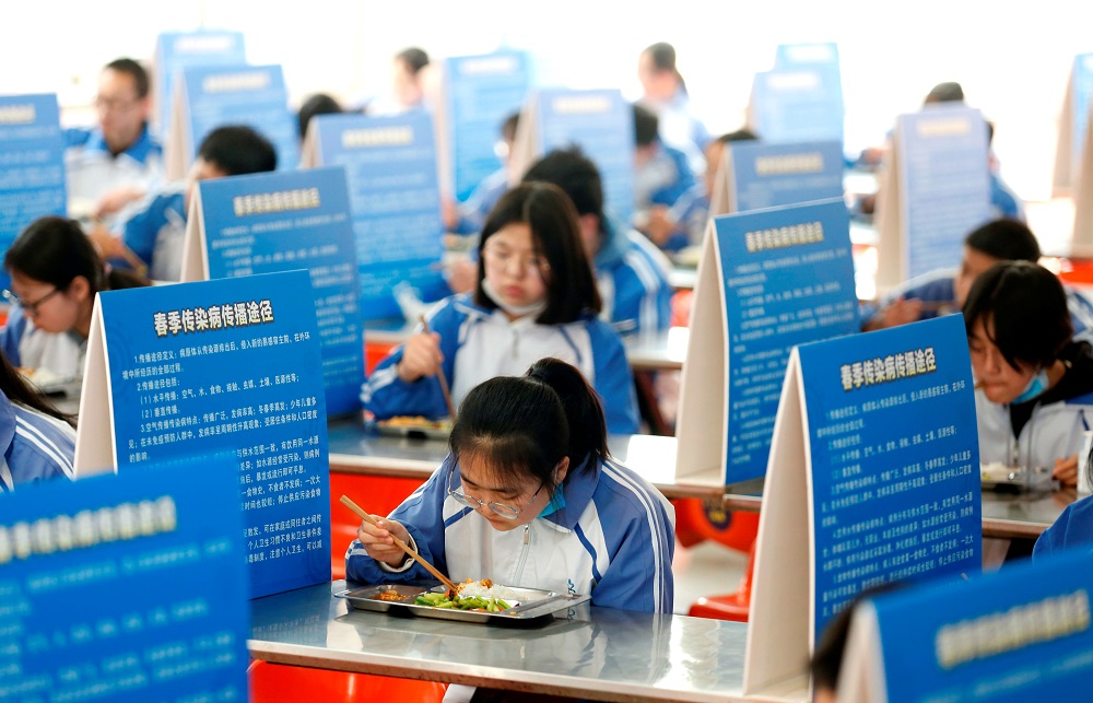 Junior three students eat at tables with partitions to prevent the spread of the novel coronavirus disease (COVID-19), at a secondary school in Weinan, Shaanxi province, China April 7, 2020. u00e2u20acu201d Reuters pic