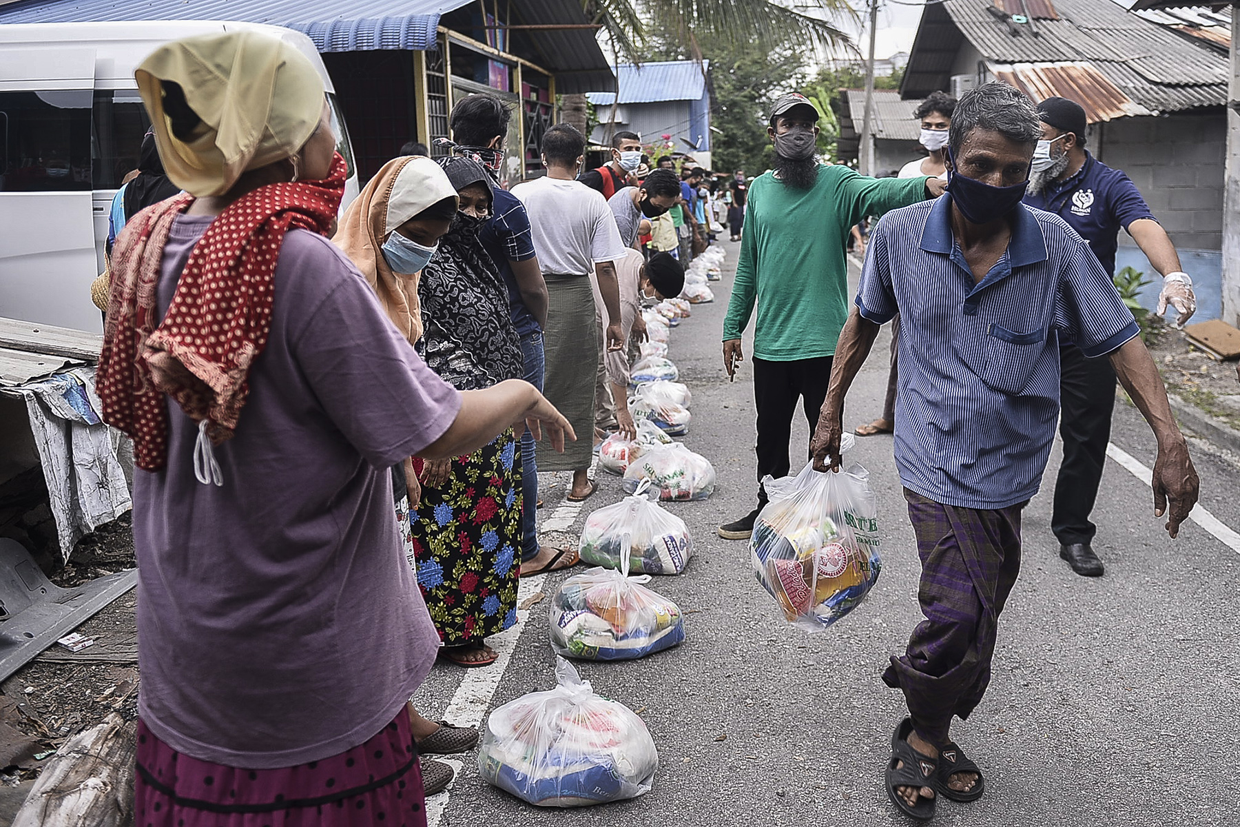 Rohingya refugees queue up for food aid distribution by NGO Human Aid Selangor at their village in Sri Gombak on April 06,2020. u00e2u20acu201d Picture by Miera Zulyana