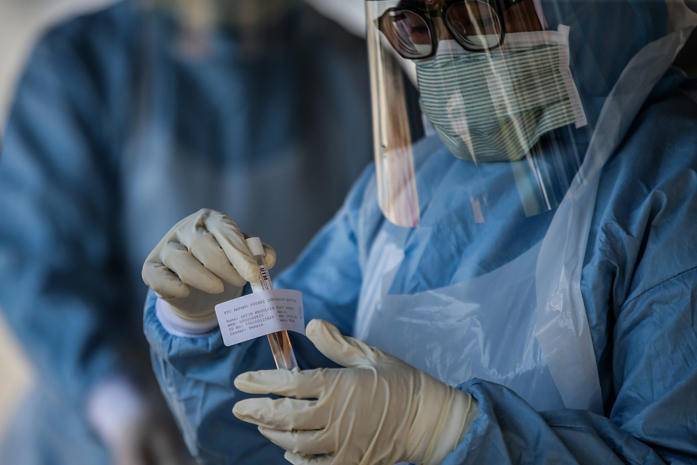 A medical worker takes a swab at a Covid-19 drive-through screening area at KPJ Ampang Puteri April 9, 2020. u00e2u20acu201d Picture by Hari Anggara