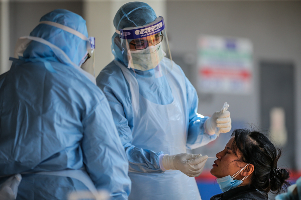 A medical worker takes a swab at a Covid-19 drive-through screening area at KPJ Ampang Puteri April 9, 2020. u00e2u20acu201d Picture by Hari Anggara