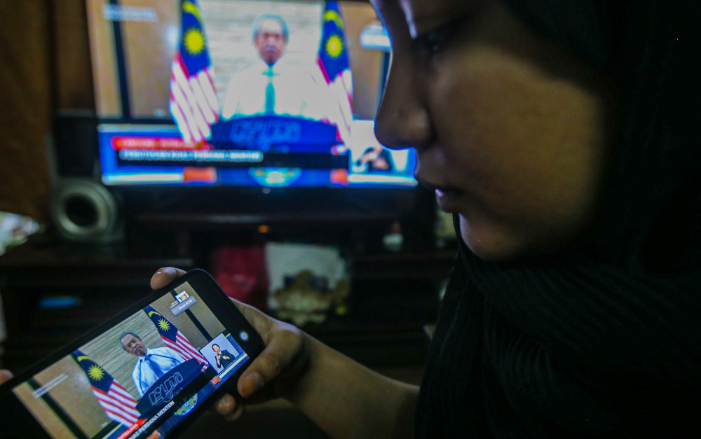 People watch the live telecast of the Prime Minister Tan Sri Muhyiddin Yassin announcing the extension of the movement control order due to the Covid-19 pandemic in Kuala Lumpur April 10, 2020. u00e2u20acu201d Picture by Hari Anggara
