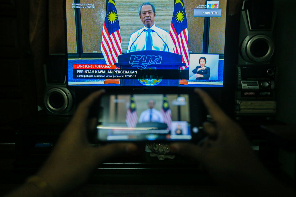 People watch the live telecast of the Prime Minister Tan Sri Muhyiddin Yassin announcing the extension of the movement control order due to the Covid-19 pandemic in Kuala Lumpur April 10, 2020. u00e2u20acu201d Picture by Hari Anggara