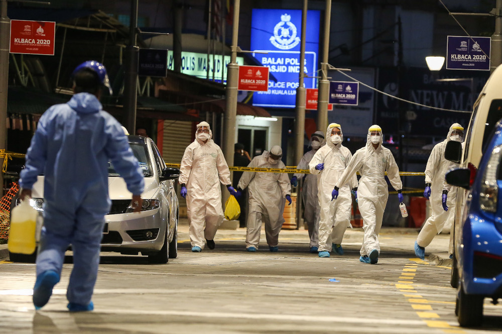 Health workers are seen disinfecting themselves after screening Selangor Mansion residents for Covid-19 in Kuala Lumpur April 11, 2020. u00e2u20acu201d Picture by Yusof Mat Isa