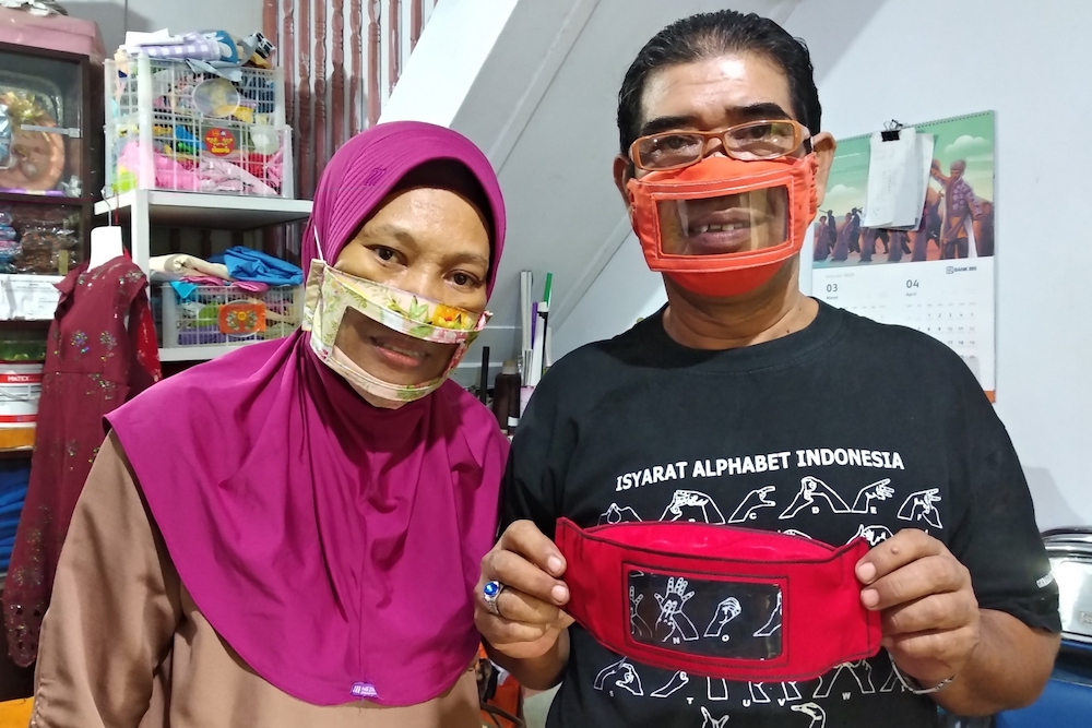 Imam Saroso and his wife Faizah Badaruddin, who are hearing and speech-impaired, pose with homemade face masks which enable people with disabilities like them to read lips when communicating, in Makassar, South Sulawesi. u00e2u20acu201d AFP pic