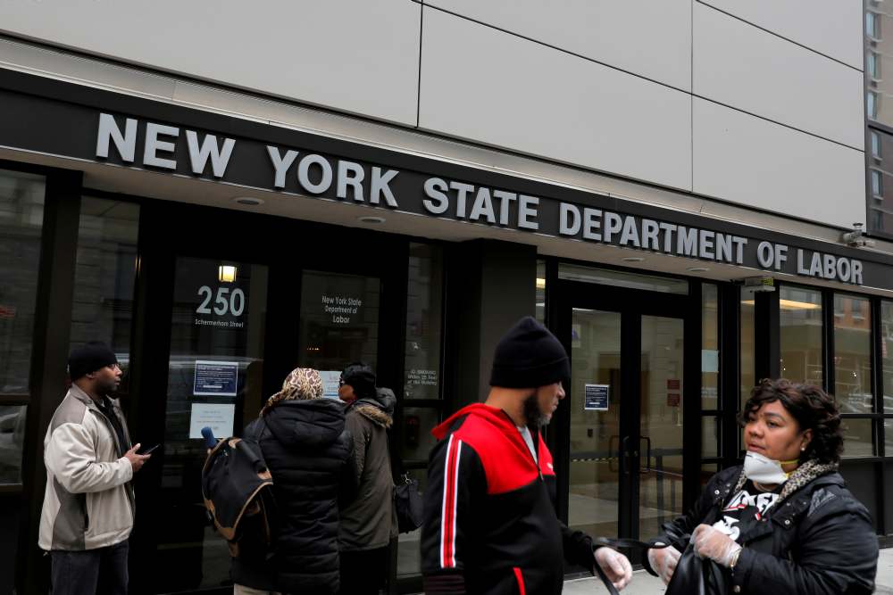People gather at the entrance for the New York State Department of Labor offices, which are closed to the public due to the Covid-19 outbreak in the Brooklyn borough of New York March 20, 2020. u00e2u20acu2022 Reuters pic