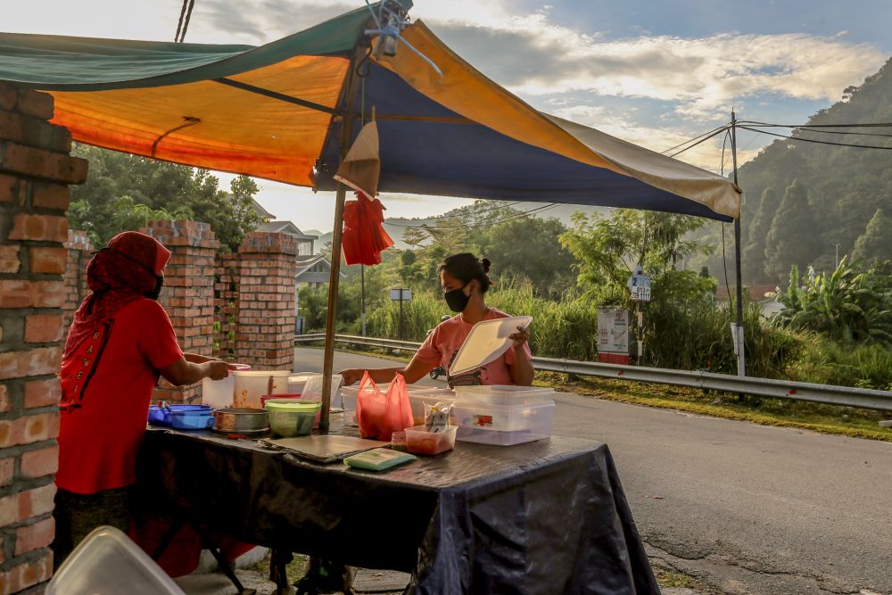 A nasi lemak vendor sets up shop during the movement control order in Gombak April 23, 2020. u00e2u20acu201d Picture by Firdaus Latif