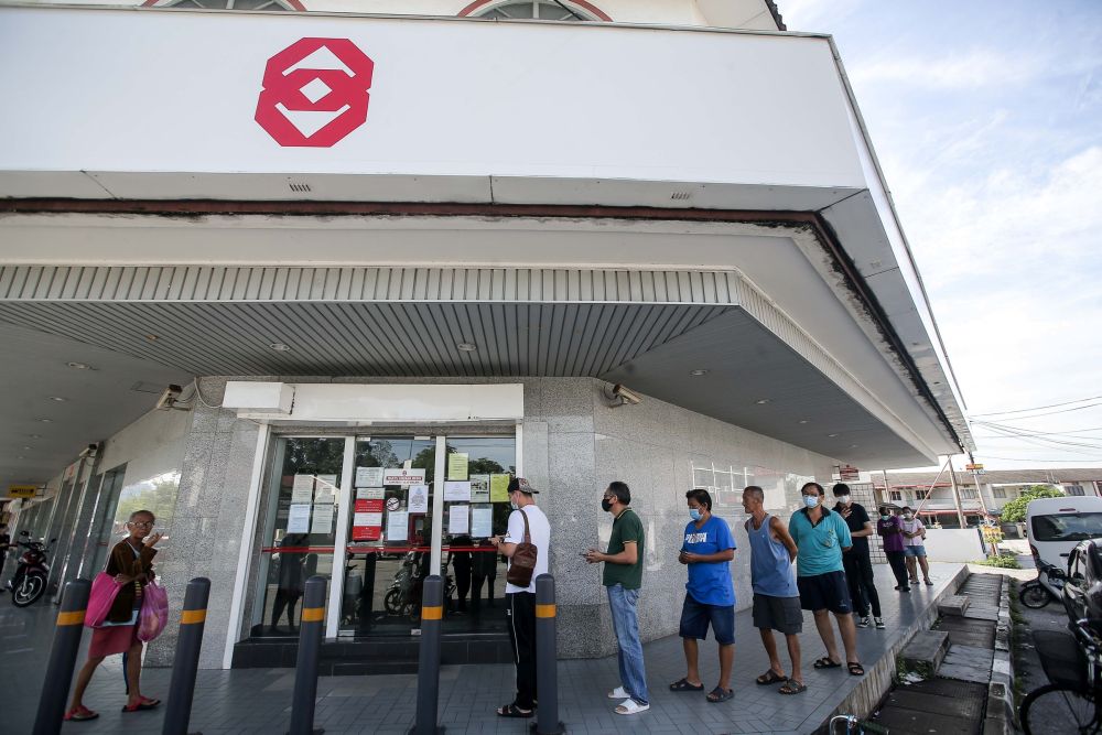 Members of the public observe social distancing guidelines as they queue outside a Public Bank branch in Ipoh March 26, 2020. u00e2u20acu201d Picture by Farhan Najib