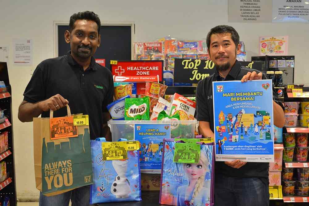 Ronan Lee (right) and General Manager of Operations Christopher Anthony making a contribution to Lend a Helping Hand Campaign 2020. u00e2u20acu201d Picture courtesy of 7-Eleven Malaysia