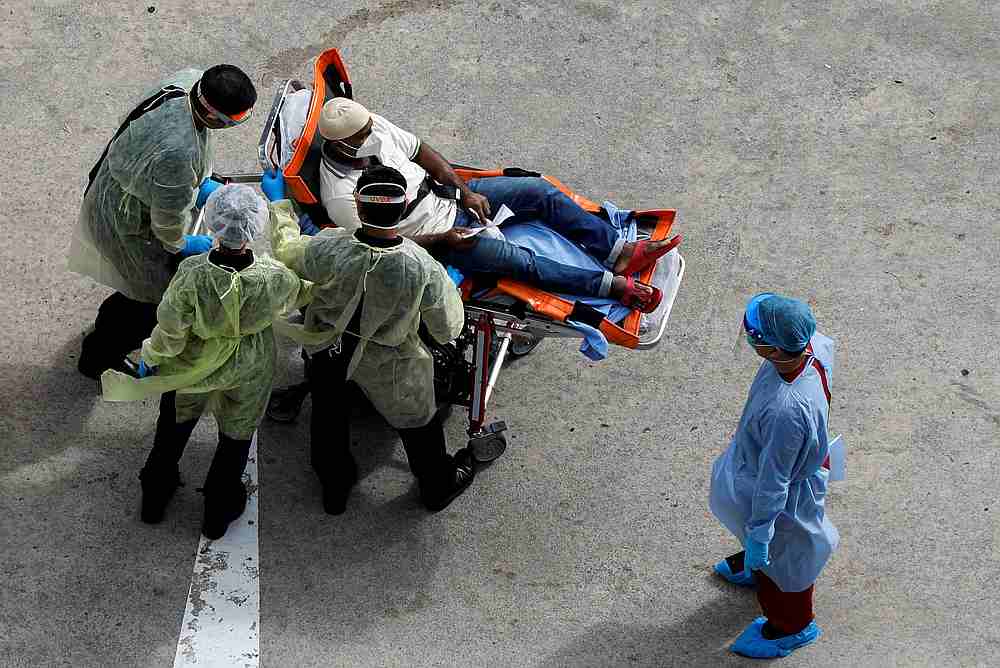 Medical personnel help a migrant worker to an ambulance at a dormitory amid the Covid-19 outbreak in Singapore, April 29, 2020. u00e2u20acu201d Reuters pic