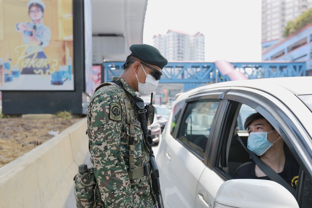 An Armed Forces personnel conducts checks on a vehicle during a roadblock in Petaling Jaya April 1, 2020. u00e2u20acu201d Picture by Ahmad Zamzahuri