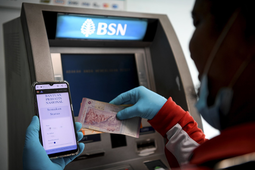 A man withdraws money from the ATM after receiving approval for the Prihatin aid package in Kuala Lumpur April 6, 2020. u00e2u20acu201d Bernama pic 