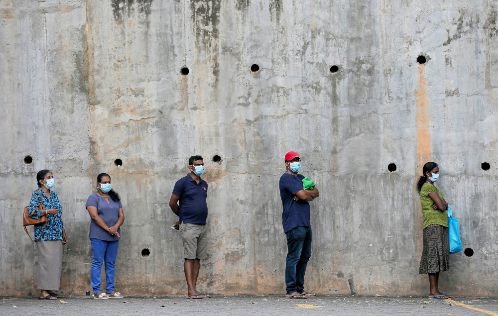 People maintain the one-metre distance between each other in Colombo, Sri Lanka, as they stand in a line to buy groceries March 24, 2020. u00e2u20acu201d Reuters pic