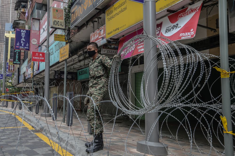 An Armed Forces personnel cordons off the vicinity of Selangor Mansion, on Jalan Masjid India, with barbed wire on April 7, 2020. u00e2u20acu201d Picture by Firdaus Latif