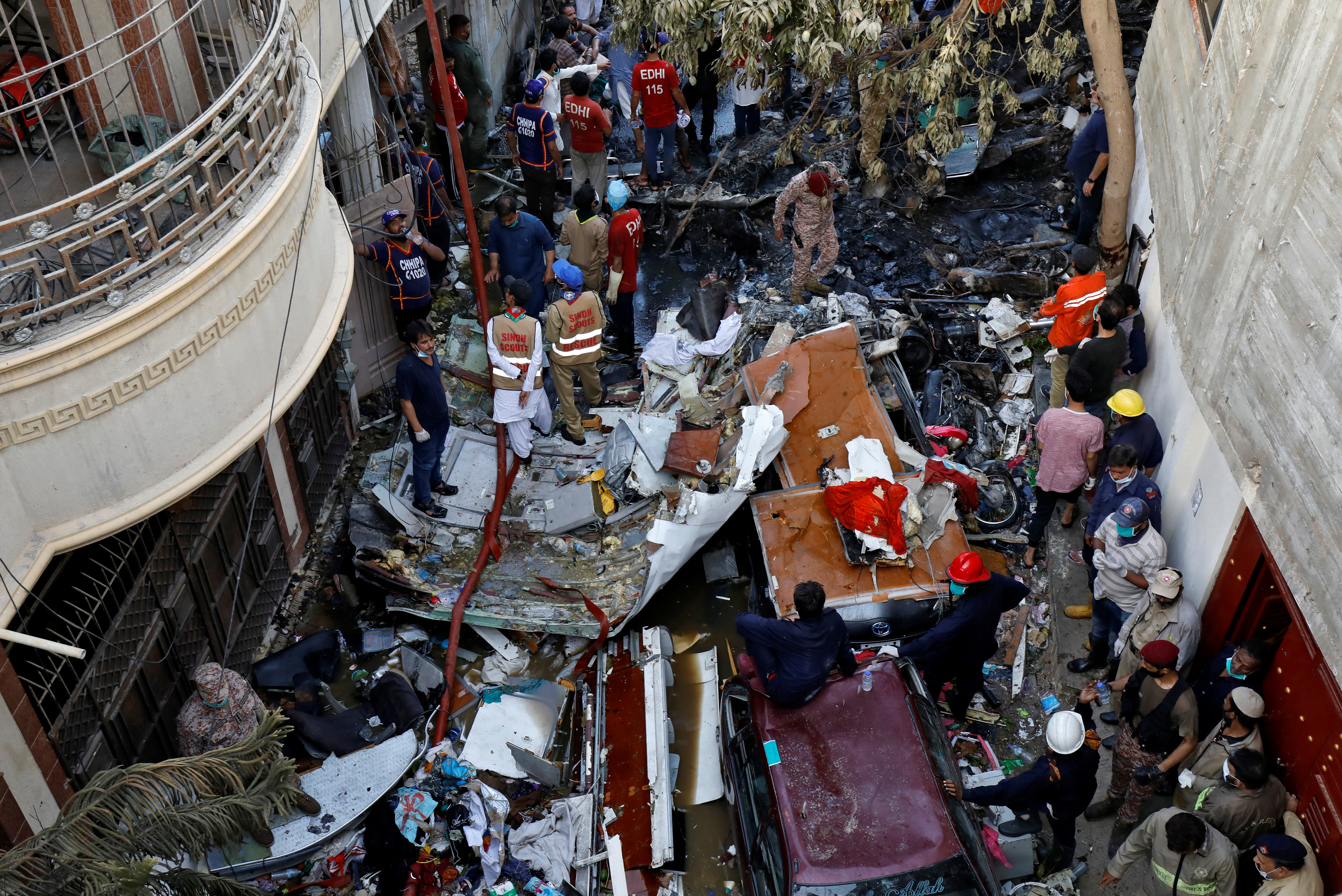 客机坠落卡拉奇真纳国际机场附近的民居，现场搜出多具遗体、客机残骸和瓦砾杂物。-路透社-