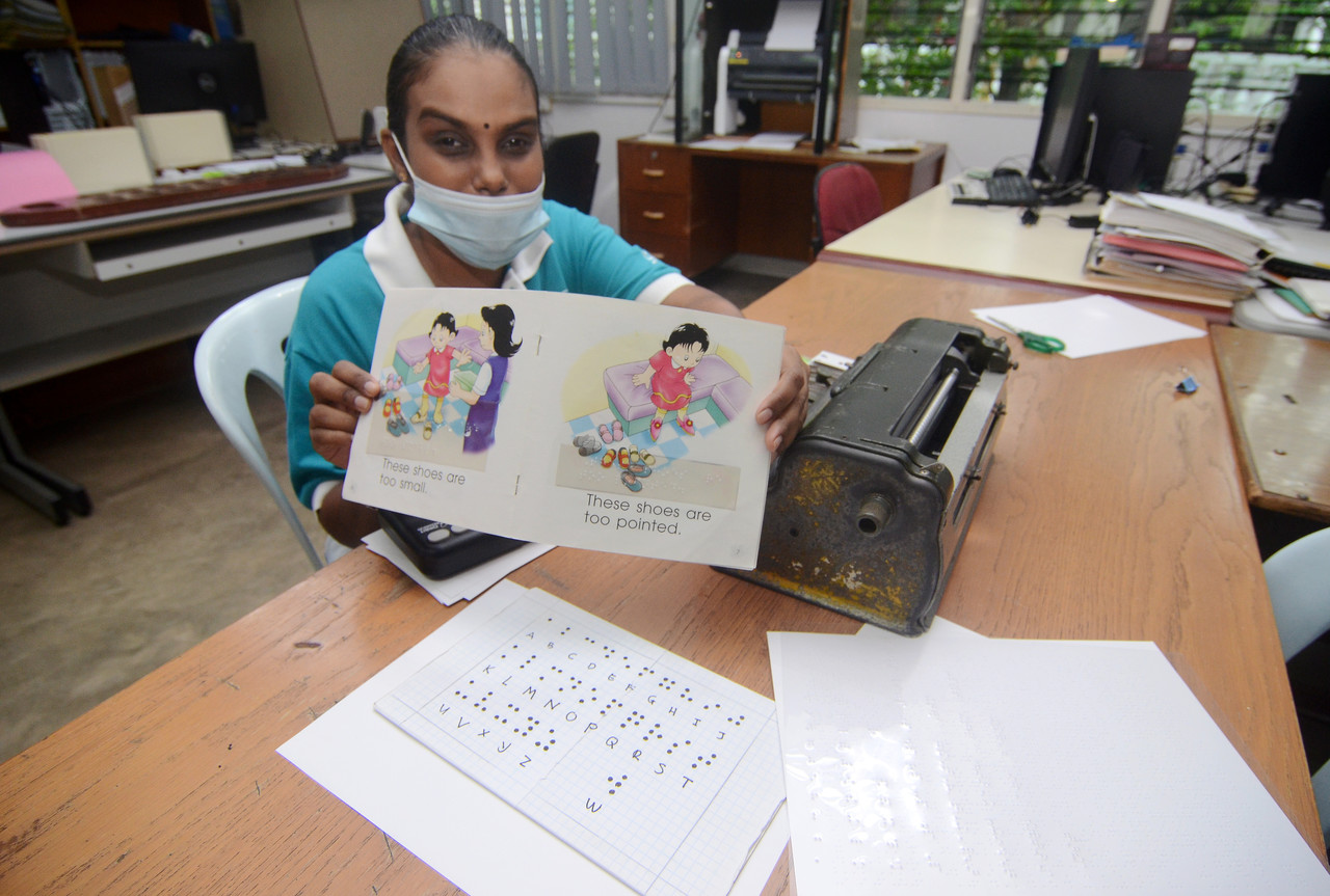 Guru Braille St Nicholas Home, S.Gomathi merupakan Orang Kurang Upaya (OKU) cacat penglihatan menunjukkan buku yang telah diterjemah dengan tulisan Braille yang diajar kepada pelajarnya selepas sesi temu bual sempena sambutan Hari Guru hari ini. u00e2u20acu201d Berna