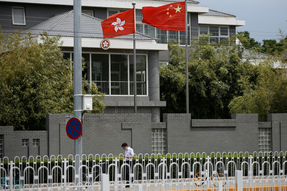 A man wearing a face mask following the coronavirus disease outbreak walks past Chinese and Hong Kong flags at the office of the Government of the Hong Kong Special Administrative Region in Beijing May 25, 2020. u00e2u20acu201d Reuters pic