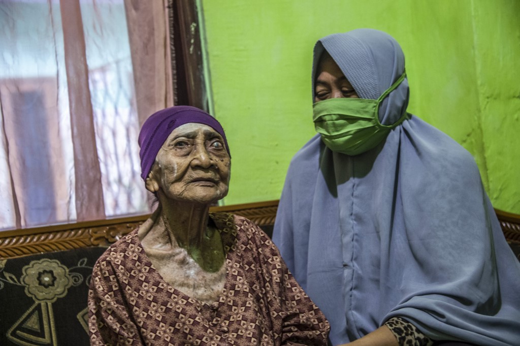 Kamtim, 100, sits in her living room with her daughter-in-law Siti Aminah (right) in Surabaya, East Java on May 31, 2020, after being discharged from a hospital earlier this week after a month of treatment from the Covi-19 coronavirus. u00e2u20acu201d AFP pic        