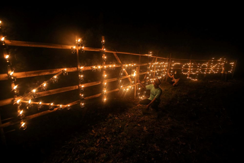 诺希达雅用了50根竹竿和500个竹制土油灯，在竹架上以挂油灯的方式，设计出清真寺造型，以及一旁的“Kita Jaga Raya Kita”标语。-Farhan Najib摄-