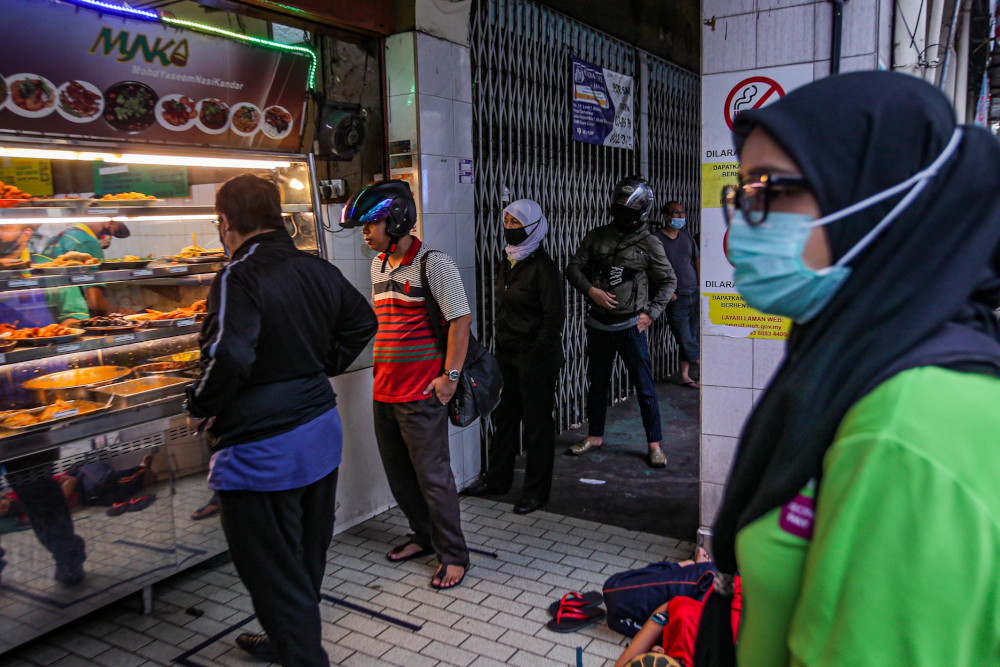 Customers queue up to buy food at Nasi Kandar Yaseem in Kuala Lumpur on the first day of the conditional movement control order (CMCO) May 4, 2020. u00e2u20acu201d Picture by Hari Anggara 