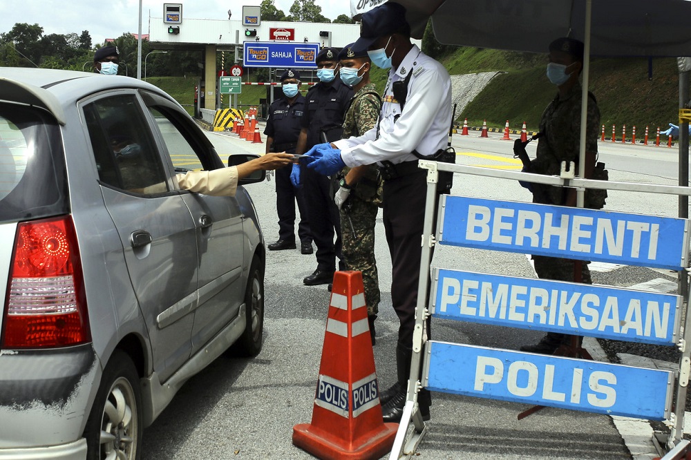 Policemen are seen at a roadblock located at the Seremban Toll Plaza during the first day of Hari Raya Aidilfitri in Seremban May 24, 2020. u00e2u20acu201d Bernama pic