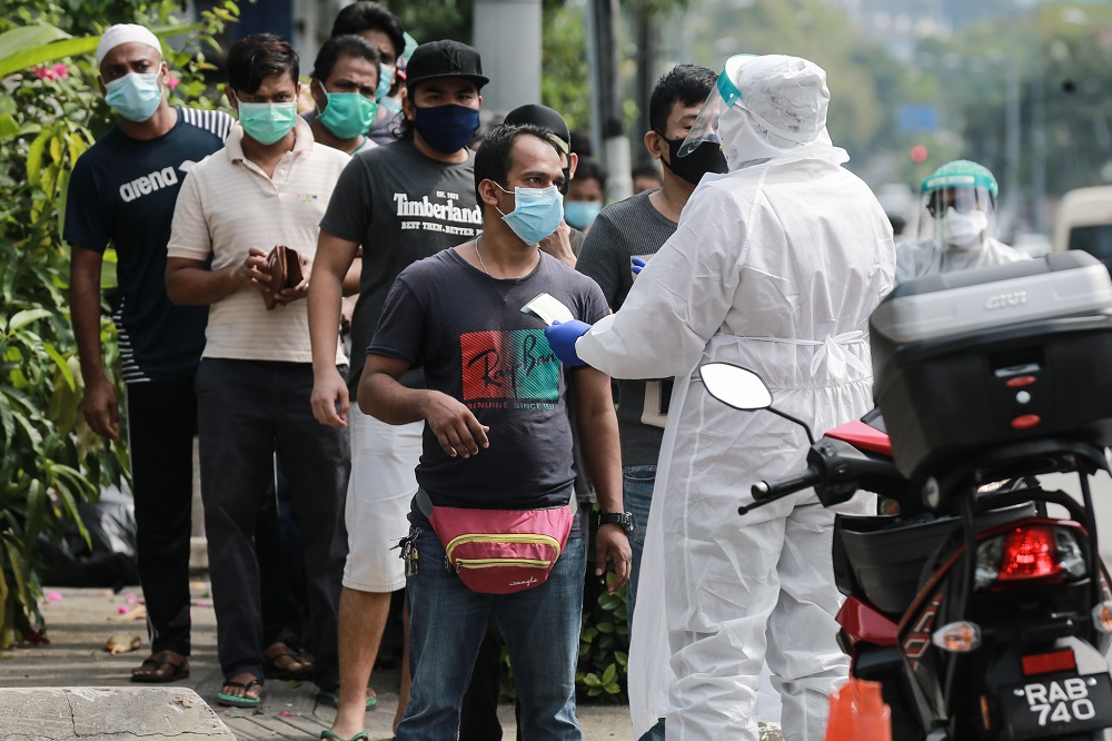 Health personnel assisting foreign workers during a Covid-19 screening in Kuala Lumpur May 8, 2020. u00e2u20acu2022 Picture by Ahmad Zamzahuri