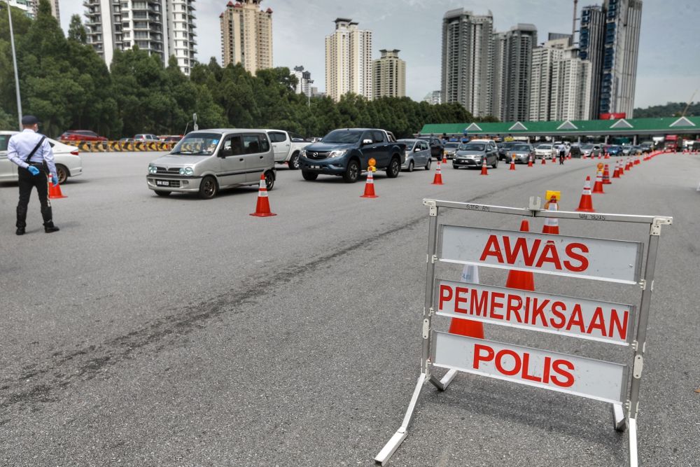 Police personnel conduct checks on vehicles at the Duta toll exit in Kuala Lumpur May 27, 2020. u00e2u20acu201d Picture by Ahmad Zamzahuri