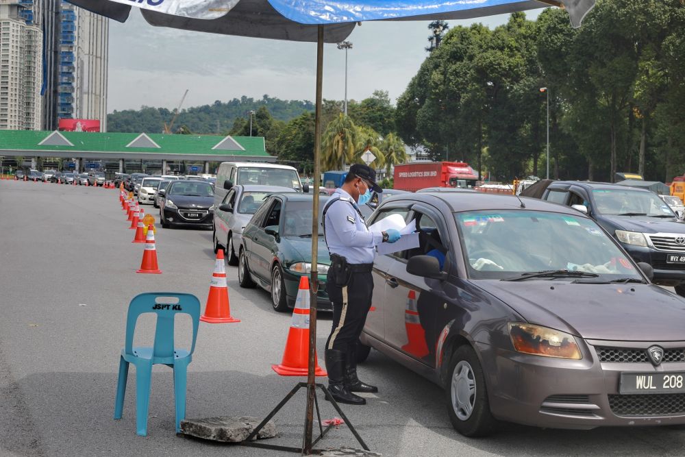 Police personnel conduct checks on vehicles at the Duta toll exit in Kuala Lumpur May 27, 2020. u00e2u20acu201d Picture by Ahmad Zamzahuri