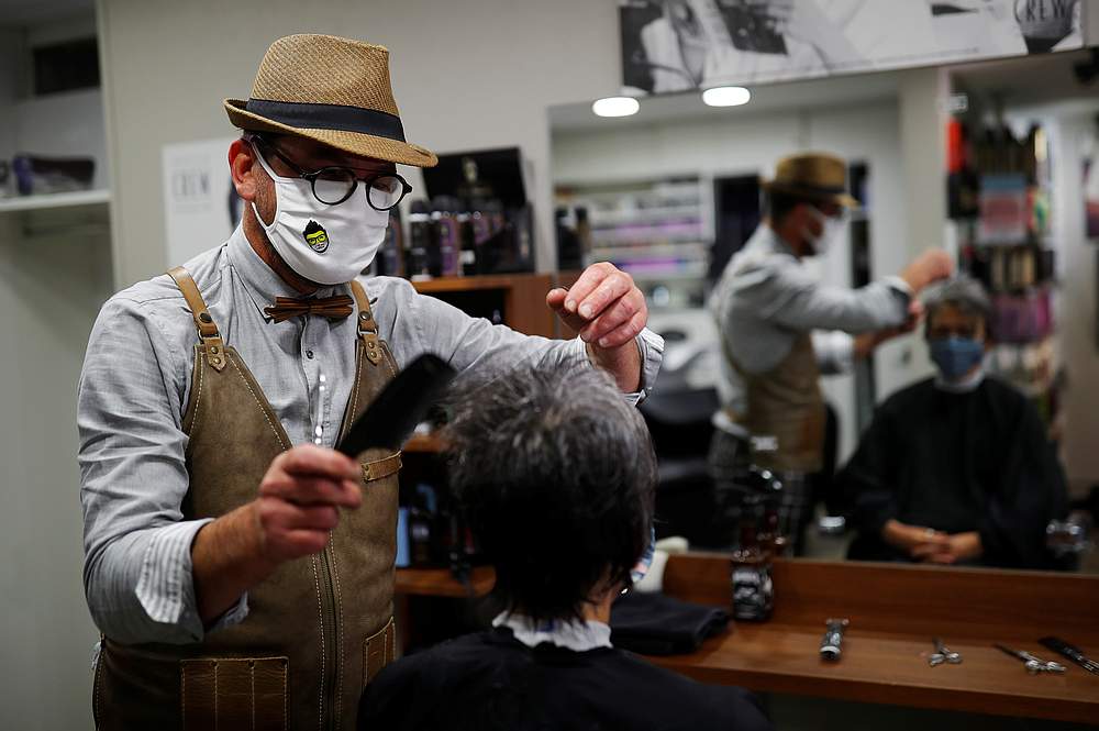 French hairdresser Marc Mauny tends to his first customer during the re-opening of Marc Creations hair salon at midnight in Mayenne, France May 11, 2020. u00e2u20acu201d Reuters pic
