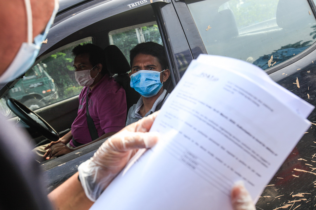 A police personnel inspects a driveru00e2u20acu2122s travel documents during a roadblock at the Jawi Toll Plaza in Penang May 19, 2020. u00e2u20acu201d Picture by Sayuti Zainudin