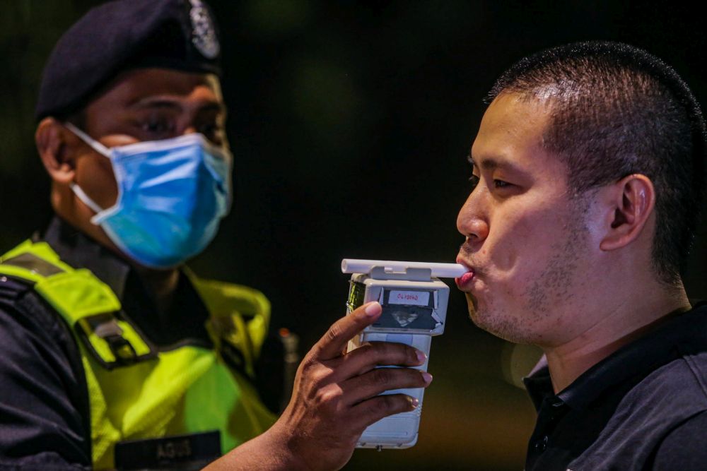 A man takes a breathalyser test at a police roadblock on Jalan Raja Laut in Kuala Lumpur May 30, 2020. u00e2u20acu201d Picture by Hari Anggara