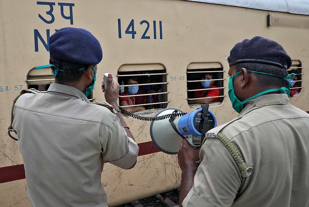 Police officers make announcements as a train arrives at a railway station on the outskirts of Kolkata, India May 5, 2020. u00e2u20acu201d Reuters pic