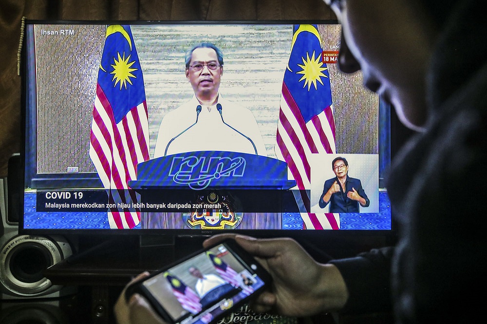 People watch the live telecast of Prime Minister Tan Sri Muhyiddin Yassin speaking about the fourth phase of the MCO in Kuala Lumpur May 1, 2020. u00e2u20acu2022 Picture by Hari Anggara