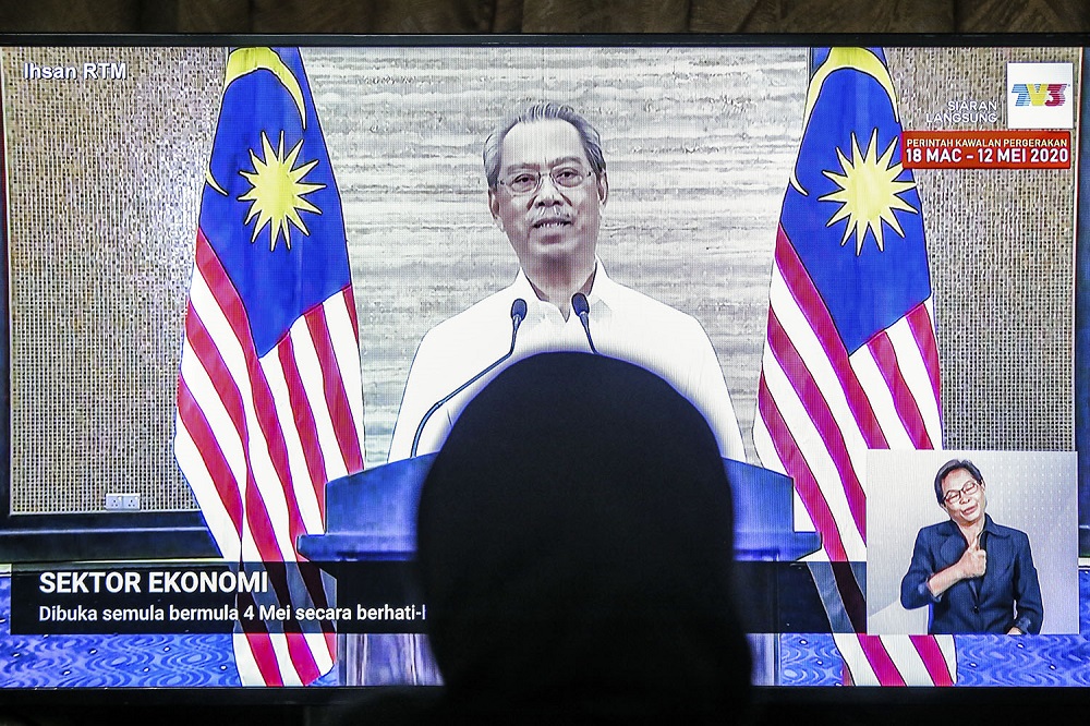 People watch the live telecast of Prime Minister Tan Sri Muhyiddin Yassin speaking about the fourth phase of the MCO in Kuala Lumpur May 1, 2020. u00e2u20acu2022 Picture by Hari Anggara