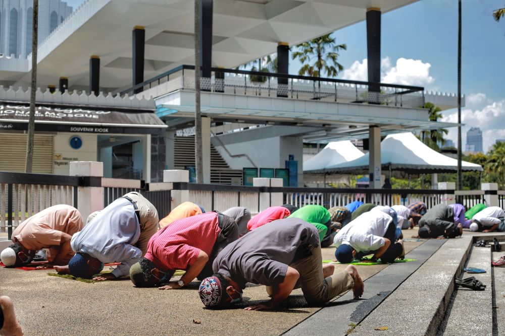 Muslims perform Friday prayers outside the National Mosque in Kuala Lumpur May 15, 2020. u00e2u20acu201d Picture by Ahmad Zamzahuri