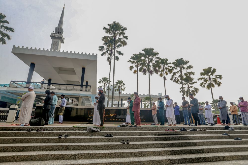 Muslims perform Eid Al-Fitr prayers outside the National Mosque before being told to leave by the police in Kuala Lumpur May 24, 2020 u00e2u20acu201d Picture by Firdaus Latifnn