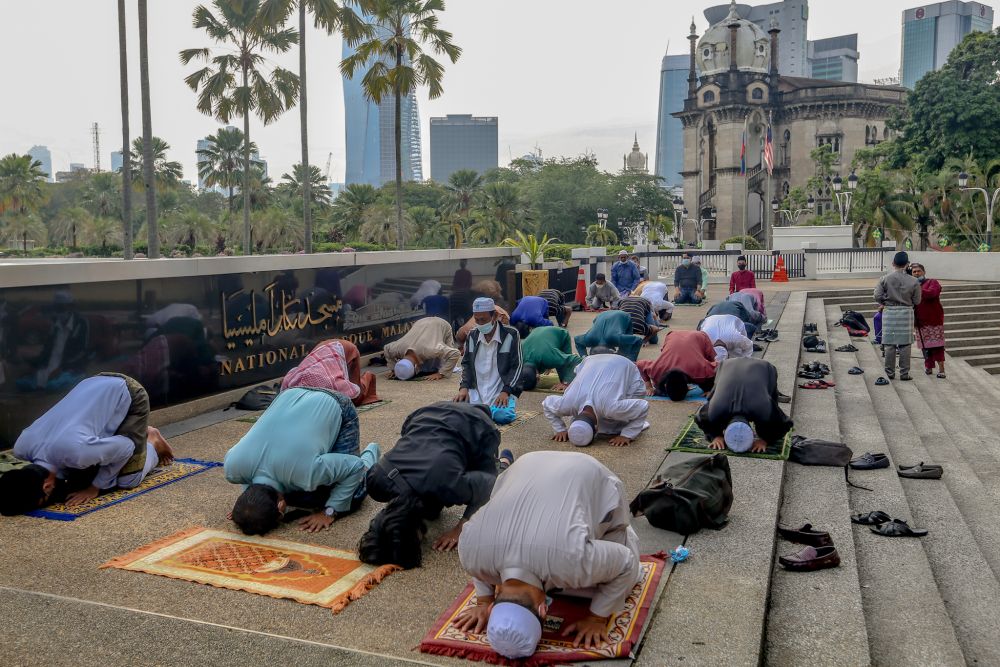 由于不能进入清真寺里，很多人士自备祈祷垫子，在国家清真寺外围祈祷。-Firdaus Latif摄-