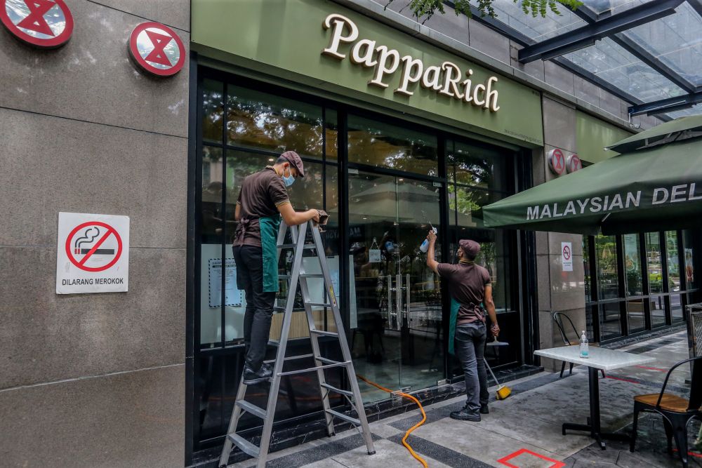 PappaRich staff carry out sanitising and cleaning work within the premises in Kuala Lumpur as eateries gets ready to resume dine-in services starting tomorrow. u00e2u20acu201d Picture by Firdaus Latif