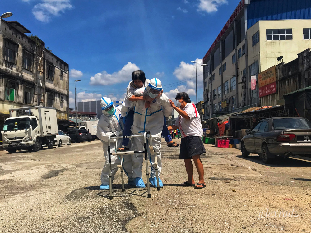 Health workers help a Pudu resident reach the Covid-19 screening area at the Pudu Market in Kuala Lumpur May 5, 2020. u00e2u20acu201d Picture by Radzi Razak