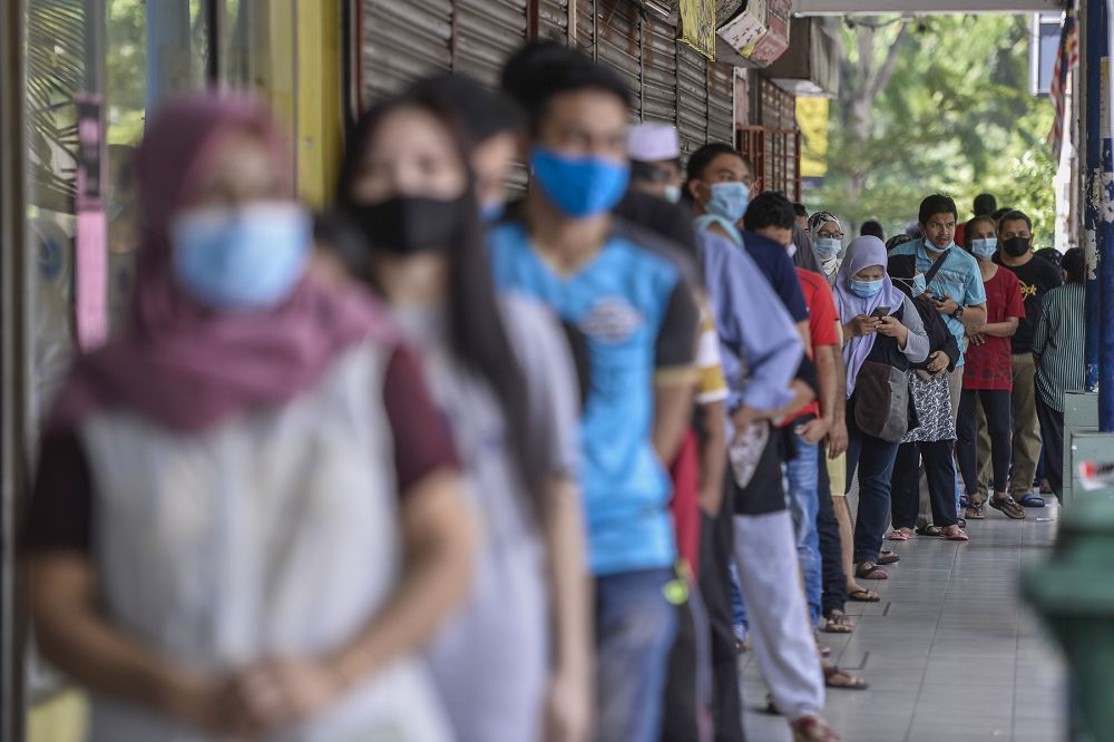 People queue up outside a Mydin hypermarket during the conditional movement control order in Shah Alam on May 6, 2020. u00e2u20acu201d Picture by Miera Zulyana