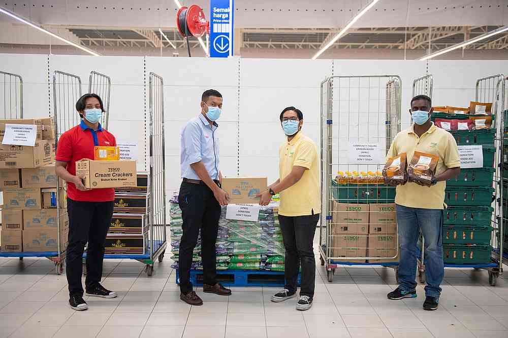 Tesco staff giving the Tabung Kiriman Ikhlas food items to Food Aid Foundation representatives for distribution. u00e2u20acu201d Picture courtesy of Tesco Malaysia